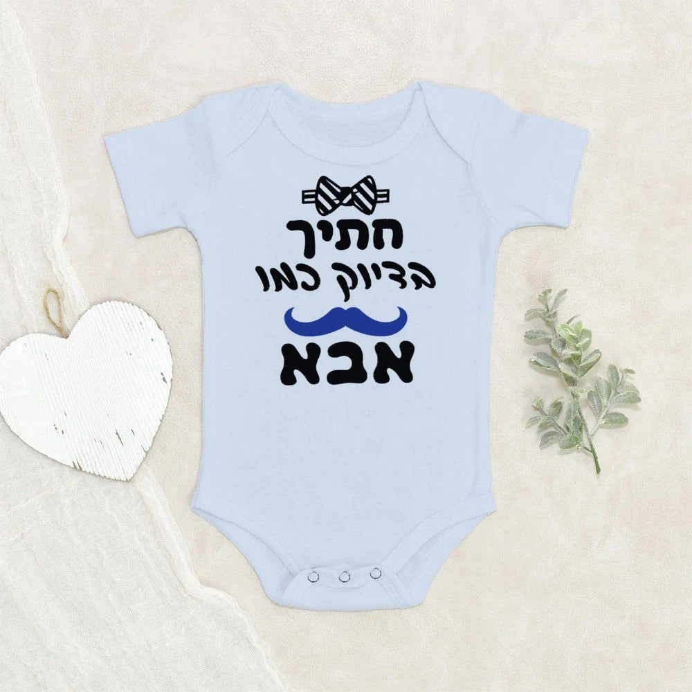 Light blue short-sleeve baby bodysuit with a black bow tie, blue mustache, and Hebrew text print.