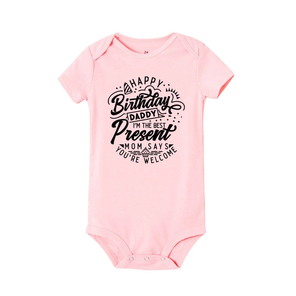 Pink short-sleeve baby bodysuit with "Happy Birthday Daddy, I'm the best present, Mom says you're welcome" text.