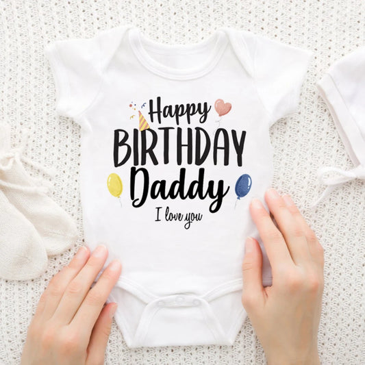 White baby bodysuit with "Happy Birthday Daddy I love you" text, party hat, balloons, and hearts.