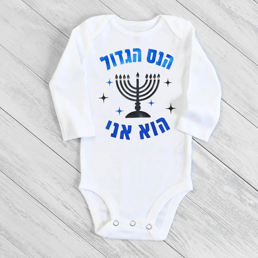 White long-sleeve baby bodysuit with blue Hebrew text, a black menorah, and stars, perfect for Hanukkah.
