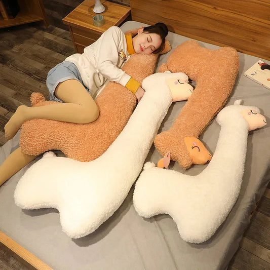 Soft white and brown alpaca plush pillows in various sizes on a bed with a person.