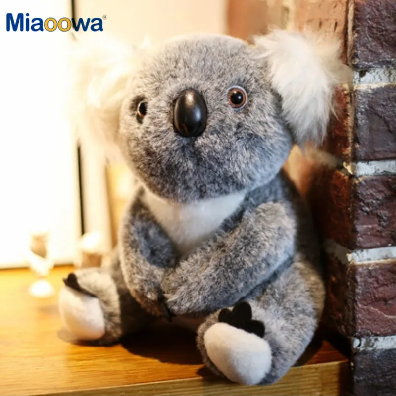 Soft gray plush koala toy with white ears and chest, black nose, and brown eyes.