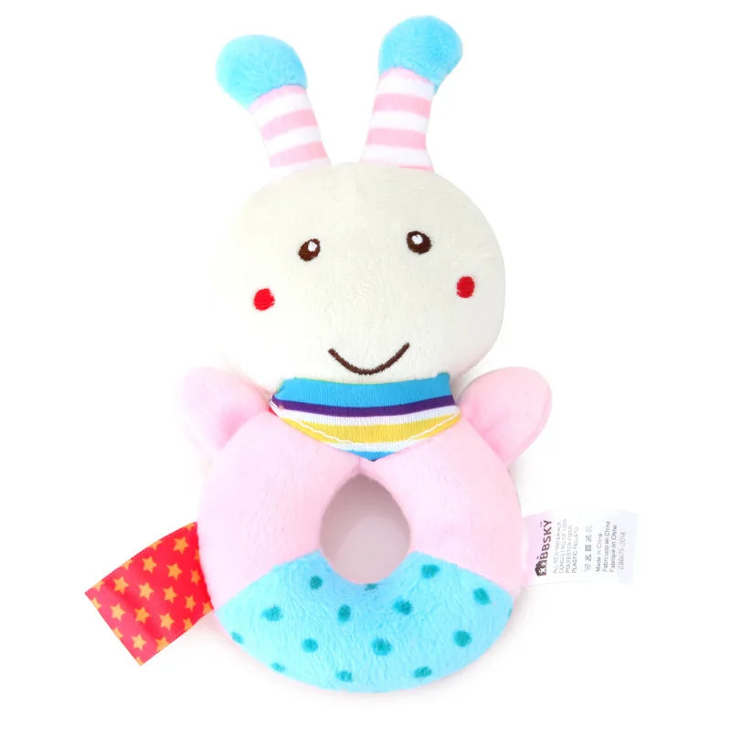 Soft plush baby rattle and teether toy with a white head, pink body, blue polka dots, and striped antennae.