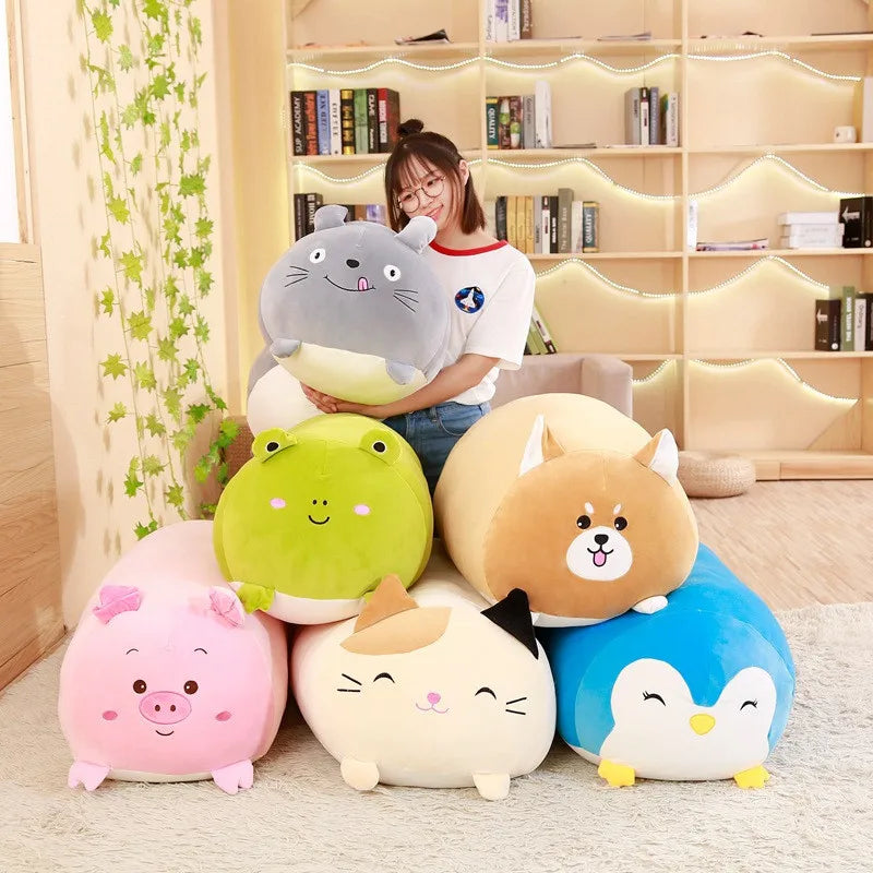 Soft plush animal pillows: grey cat, green frog, pink pig, cream cat, brown dog, and blue penguin.