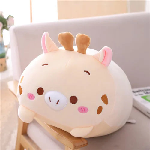 Soft beige plush animal toy with pink ears, brown antlers, and spotted details, resting on a chair.