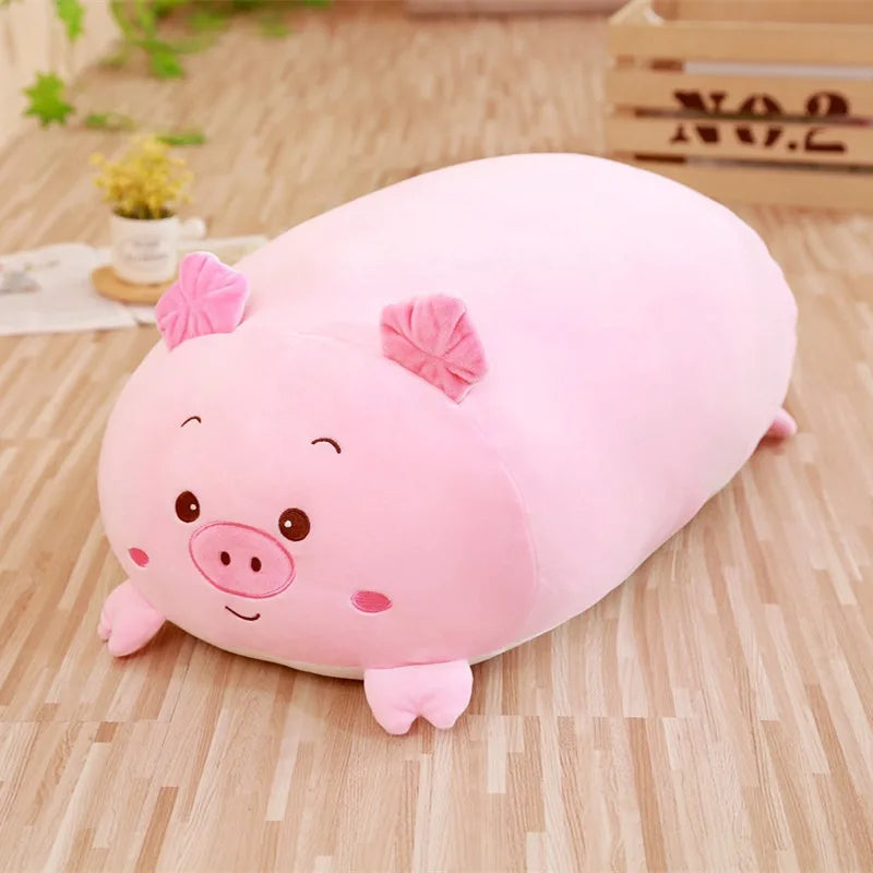 Soft pink plush pig animal pillow for babies, 25cm, on a wooden floor.