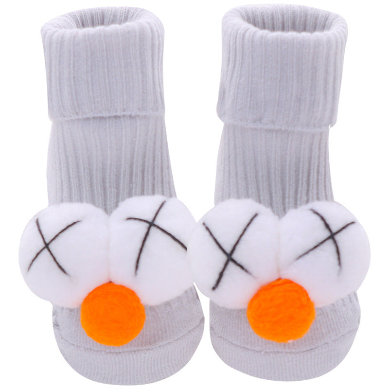 Pair of soft gray cotton baby socks with white plush "X" eyes and orange pom-pom noses, anti-slip.