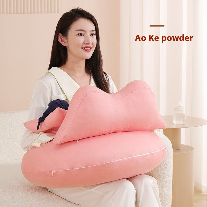 Smiling woman holding a pink, multi-functional maternity and nursing pillow with a removable top section.