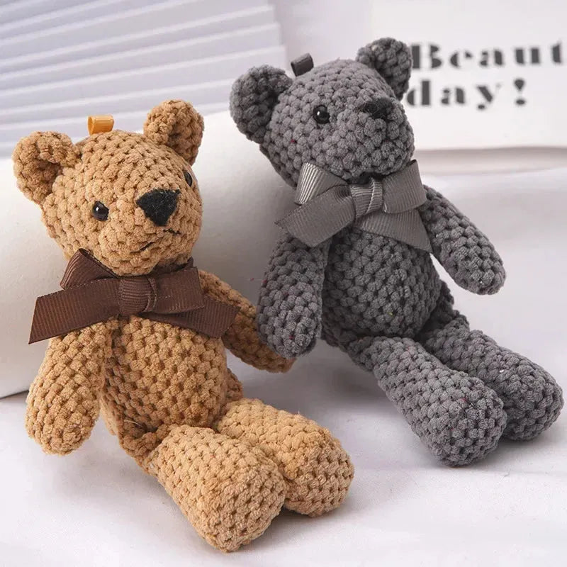 Two soft plush teddy bears, one brown with a brown bow, one gray with a gray bow.