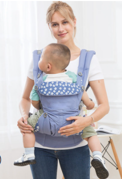 Woman wearing a blue ergonomic baby carrier with a floral pattern, holding a baby facing forward.