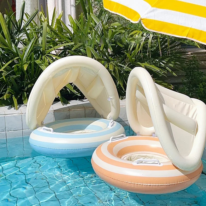 Two inflatable baby swimming floats with sun canopies, one light blue striped and one orange striped, in a pool.