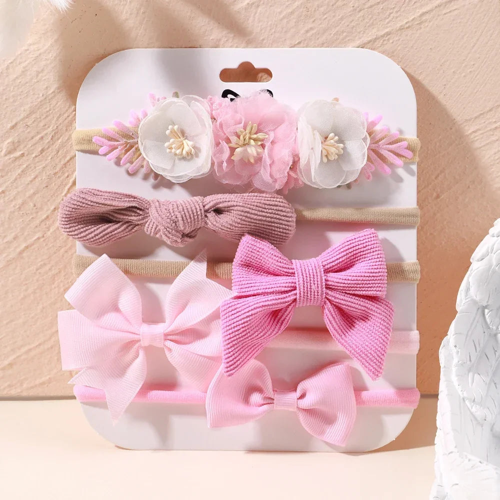 Set of 5 pink baby headbands with lace flowers, ribbed bows, and satin bows.
