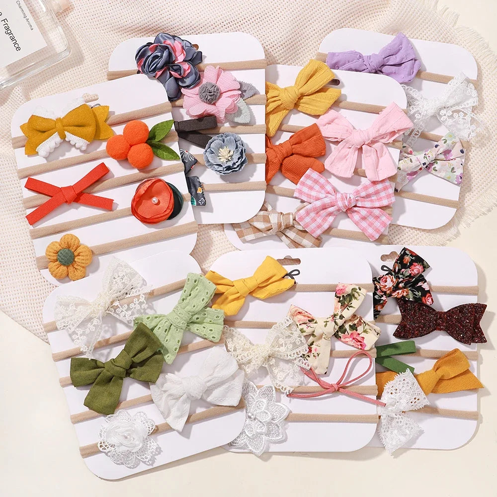 Set of 5 baby headbands with various lace flowers, bows, and fabric designs in assorted colors.