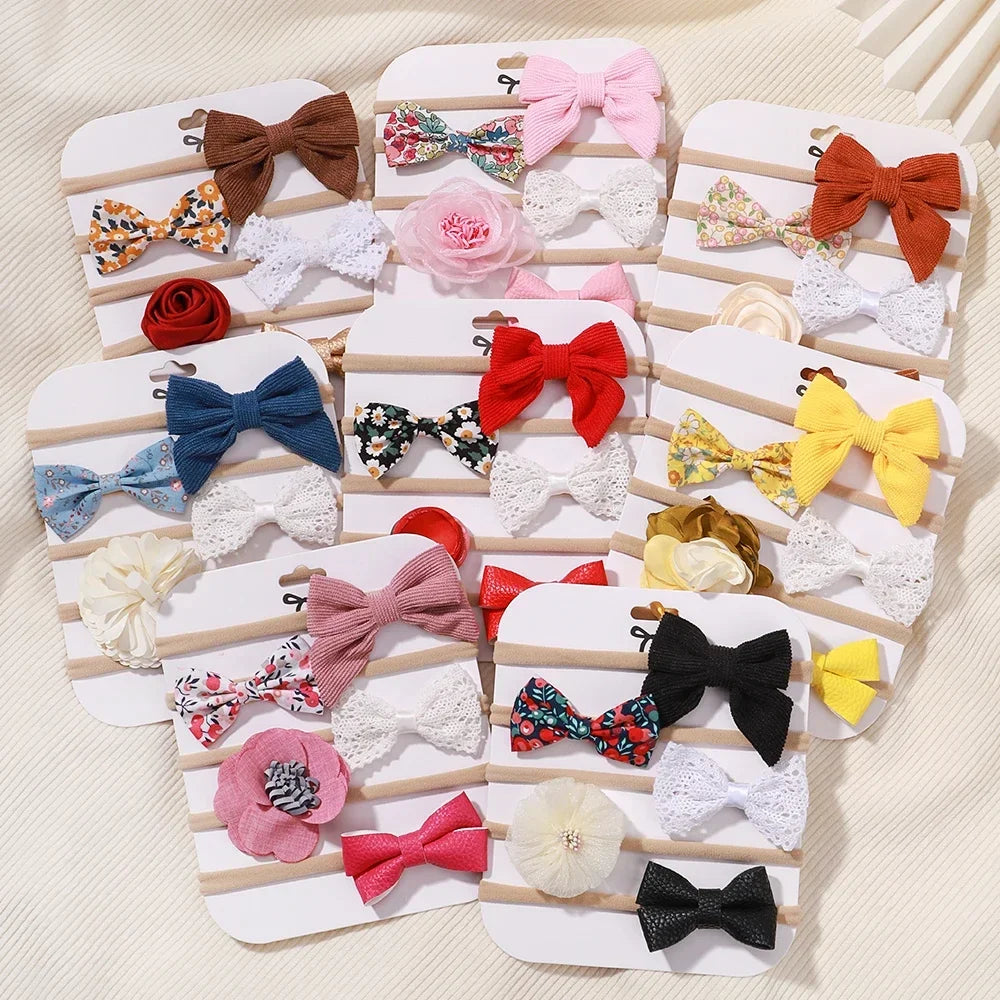 Set of 5 baby headbands with various lace flowers, bows, and fabric designs in multiple colors.