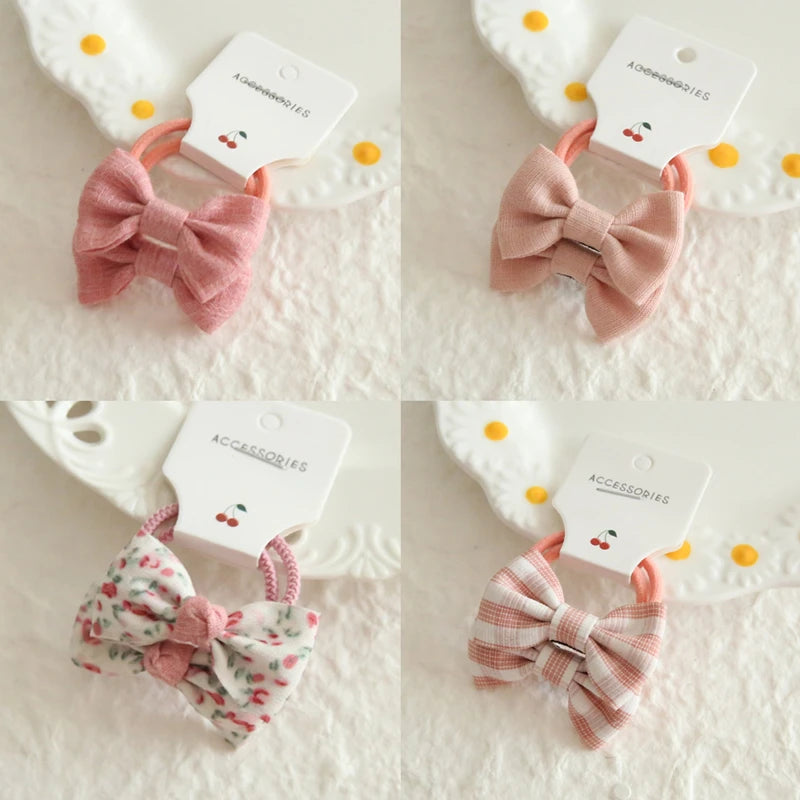 Four soft cotton hair ties for babies and girls, featuring pink bows, floral, and striped designs.