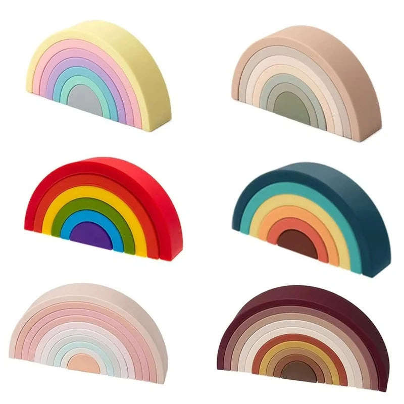 Six soft silicone rainbow stacking toys in various pastel and vibrant color schemes.