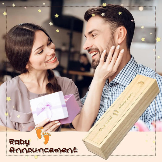 Happy couple with a light wood pregnancy test keepsake box engraved "Our next adventure" and baby footprints.