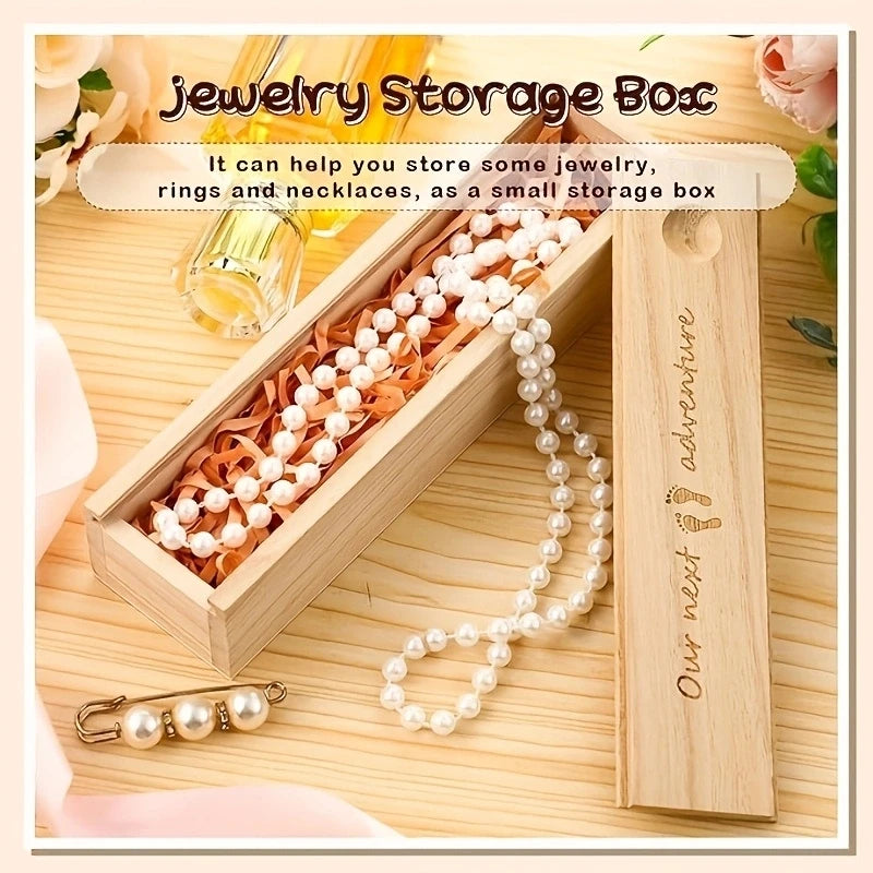 Light wood keepsake box with "Our next adventure" engraving, holding a pearl necklace and a pearl safety pin.