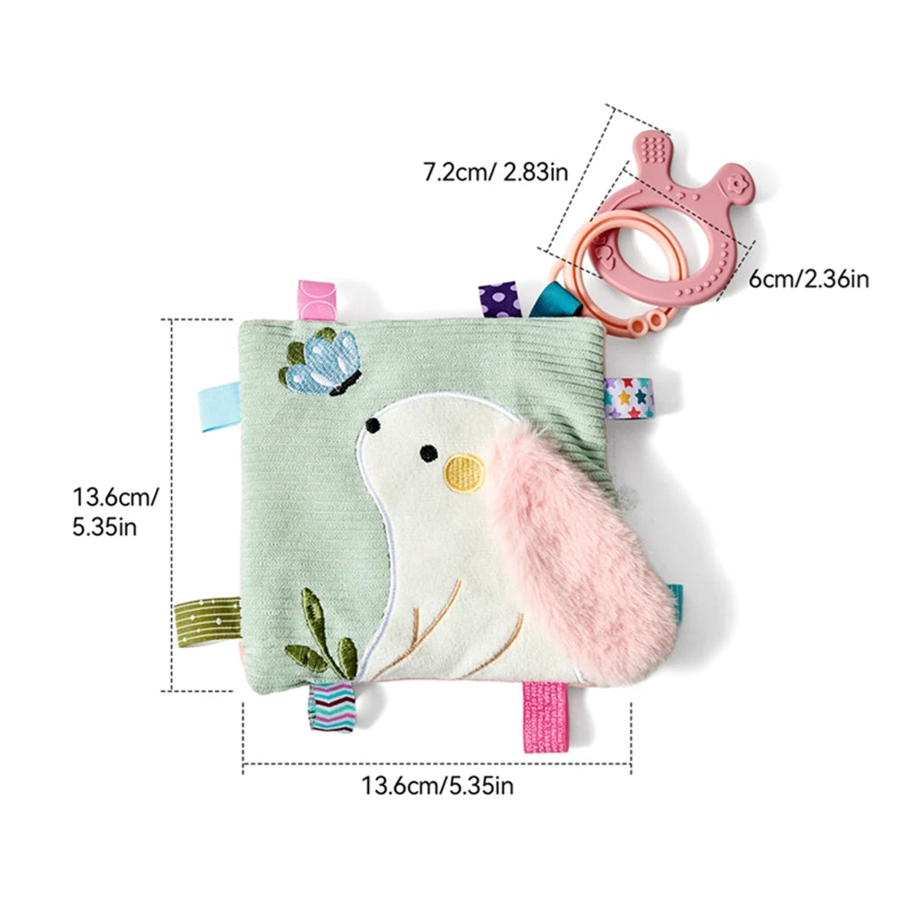 Soft green sensory baby blanket with a white bunny, butterfly, textured tags, and a pink teether.