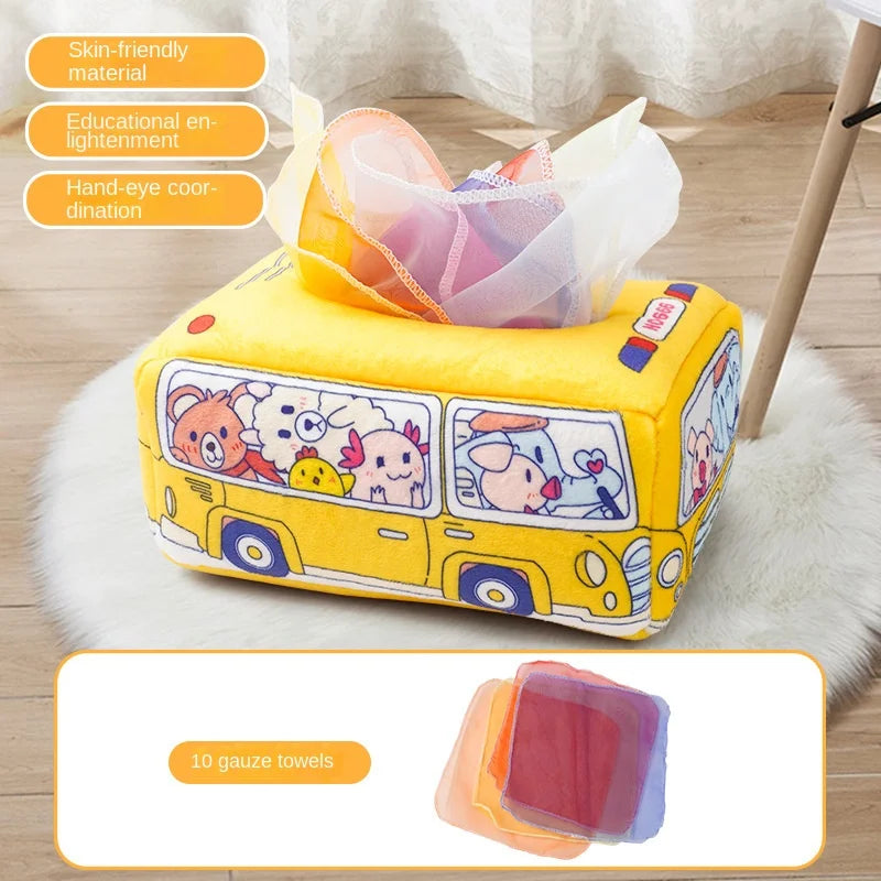 Yellow plush Montessori tissue box toy shaped like a bus with animal characters and colorful gauze scarves.