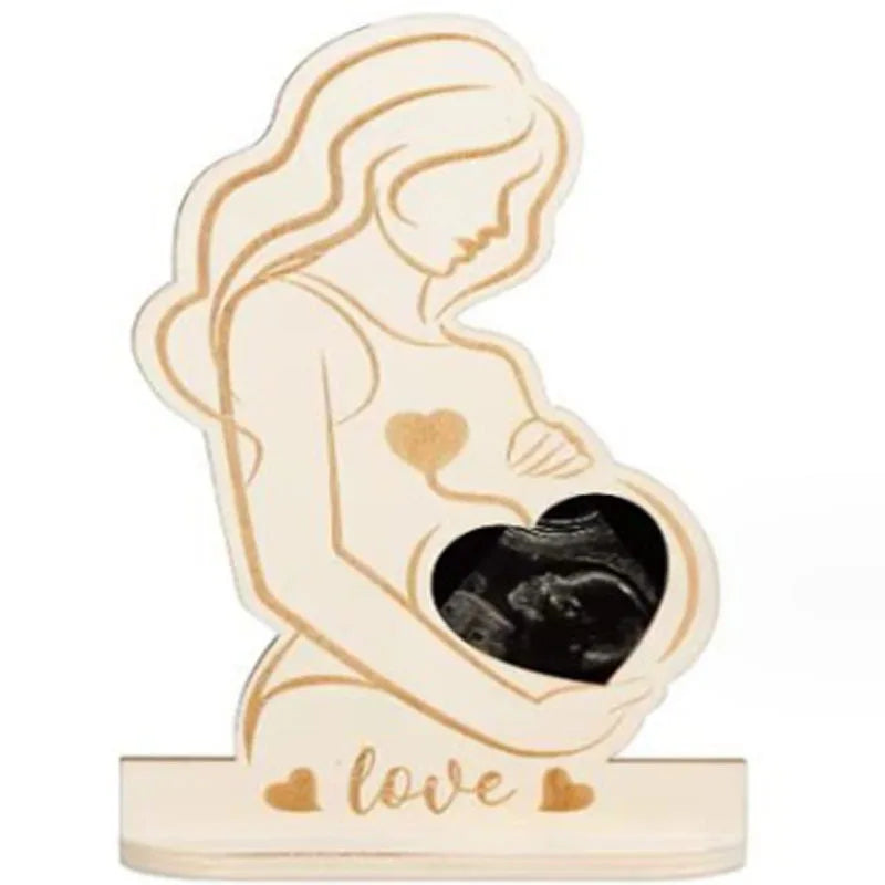 Wooden pregnancy keepsake with a heart-shaped ultrasound photo cutout and "love" engraved on the base.