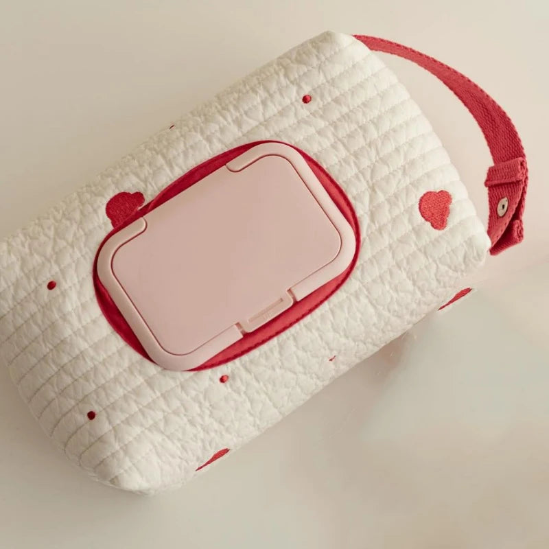 Quilted white cotton tissue and wipe holder with red heart embroidery, pink dispenser lid, and red hanging strap.