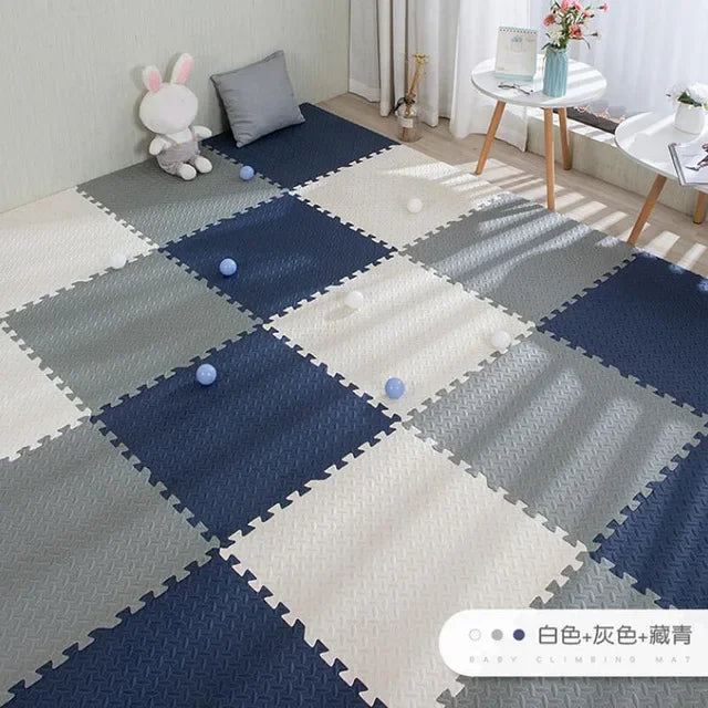 Interlocking EVA foam play mat in white, gray, and navy blue, with a textured surface for babies.