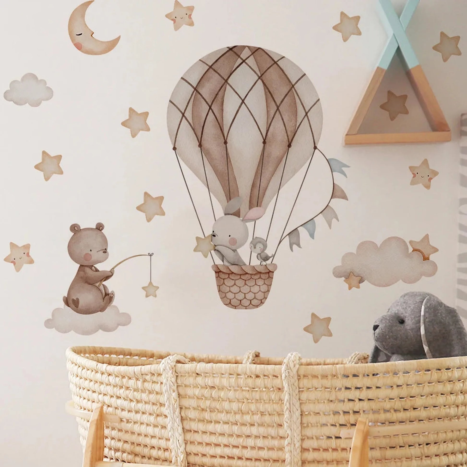 Nursery wall decals with a bear fishing on a cloud, a rabbit and bird in a hot air balloon, stars, and a crescent moon.