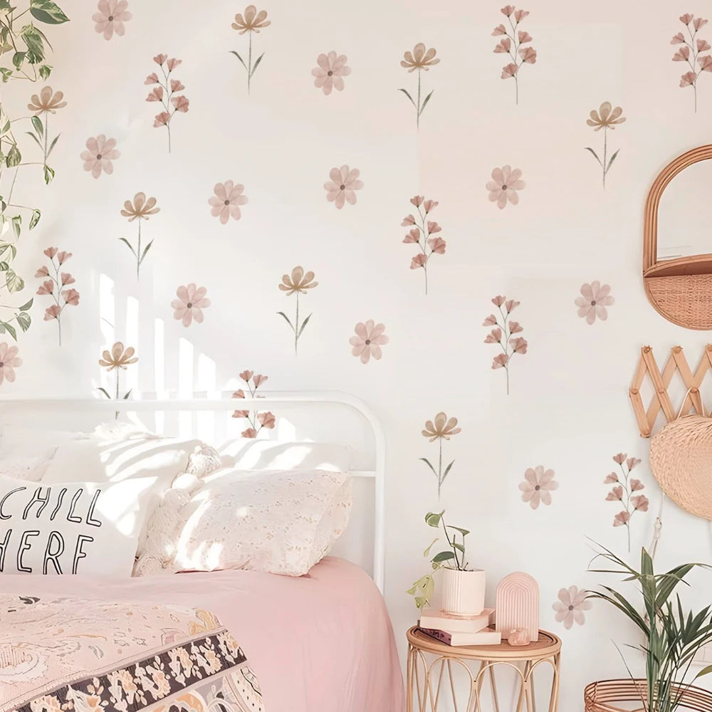 Watercolor flower wall decals in pink and beige, decorating a child's bedroom with a white bed and plant.