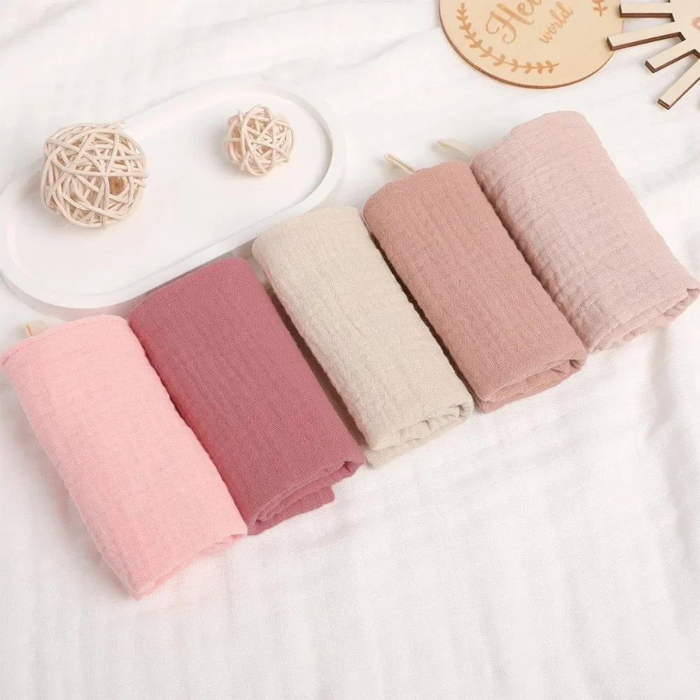 Soft pink and beige 100% cotton gauze baby towels, multi-layered for high absorbency.