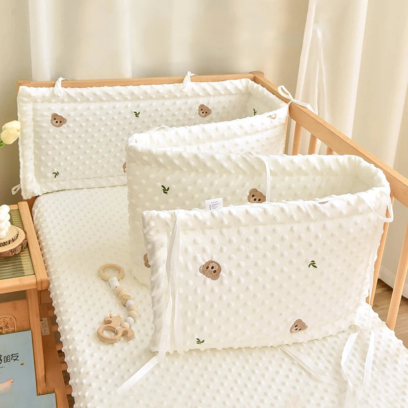 Soft white polyester baby crib bumper with cute embroidered bear and leaf cartoon designs.