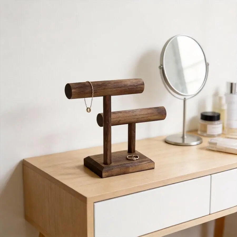 Dark wood jewelry organizer stand with two horizontal bars for watches and bracelets on a light wood vanity.