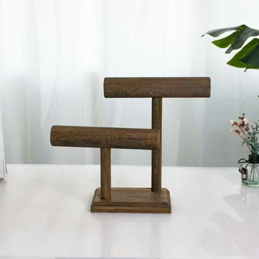 Dark brown wooden two-tier jewelry organizer stand for watches and bracelets on a white surface.