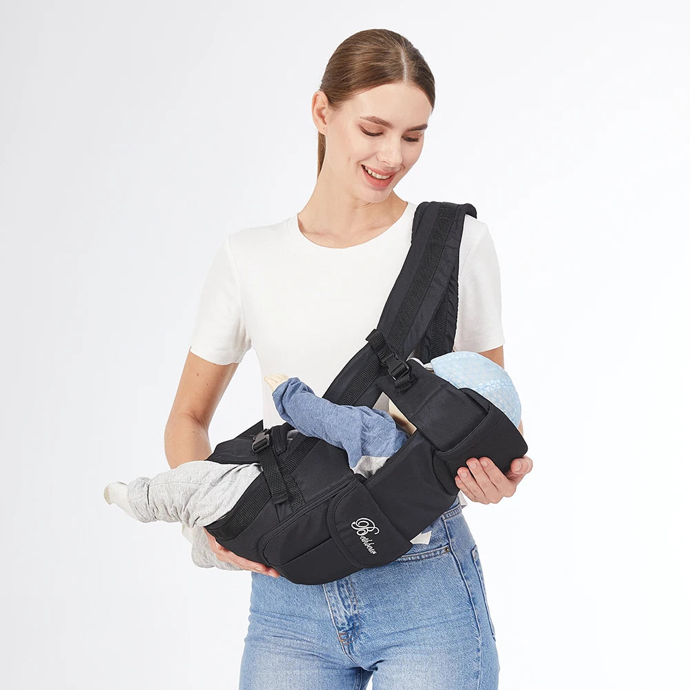 Smiling woman holding a baby in a black ergonomic 4-in-1 baby carrier, showcasing its comfortable design.