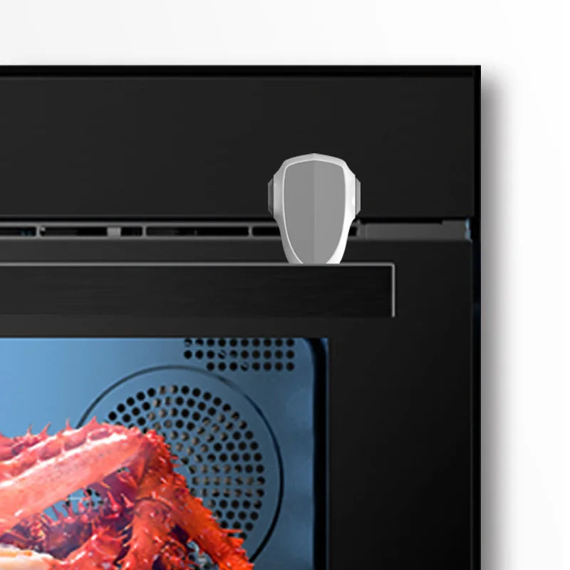 Gray child safety lock on a black oven, preventing access to the door.