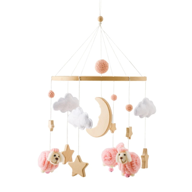 Wooden crib mobile with pink felt sheep, white clouds, and wooden moon and stars.
