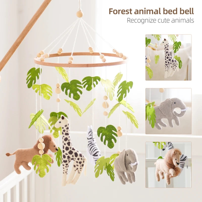 Wooden crib mobile with felt forest animals and green leaves.