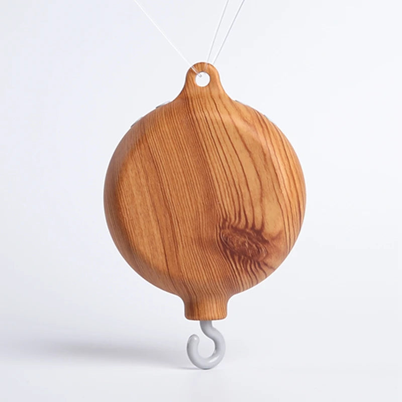 Wooden musical crib mobile base with natural wood grain and a gray hook.