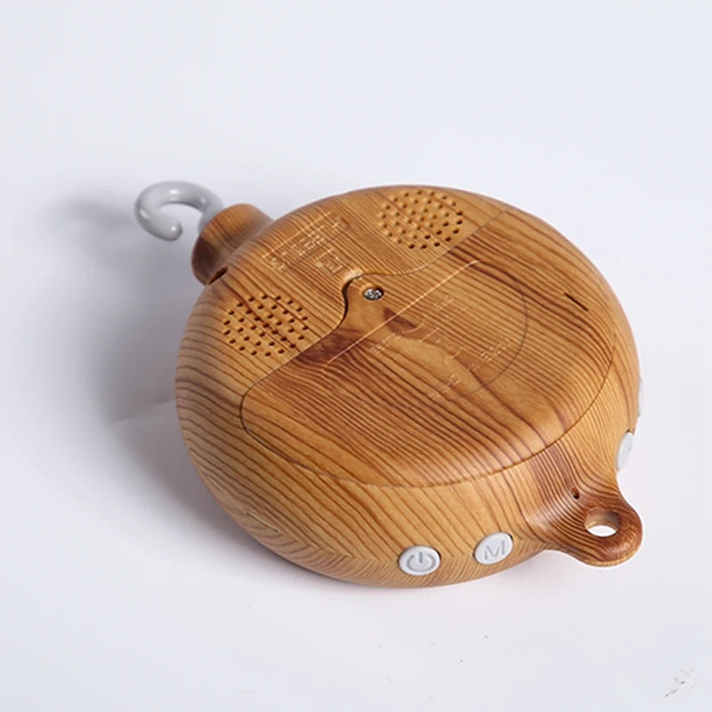 Wooden musical crib mobile motor with hook, natural wood grain, and control buttons.