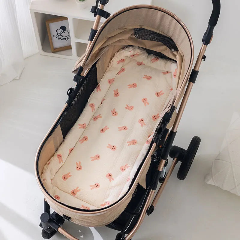Soft beige stroller cushion with pink bunny print, designed for baby comfort.