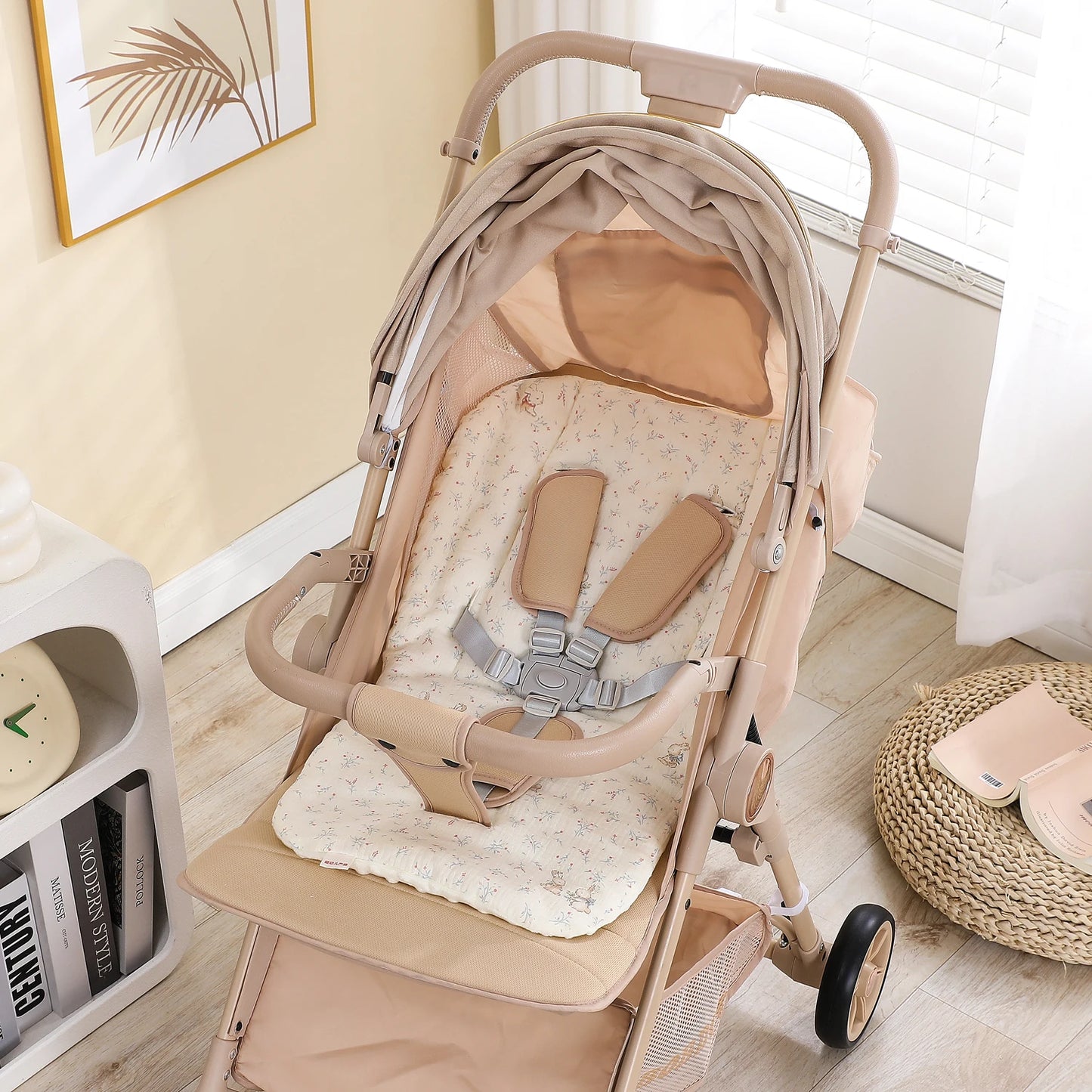 Beige stroller with a soft, patterned seat cushion and safety harness.