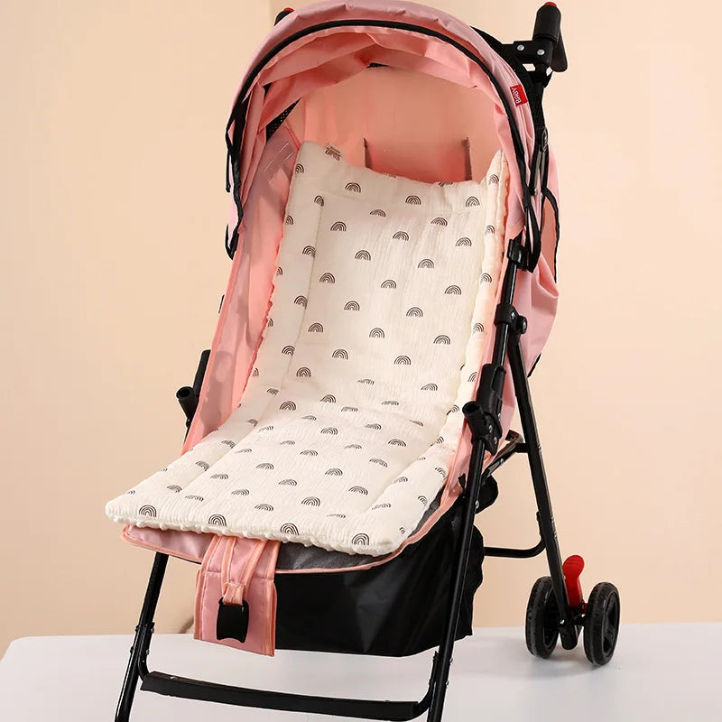 Soft white baby stroller cushion with black rainbow pattern, inside a pink stroller.