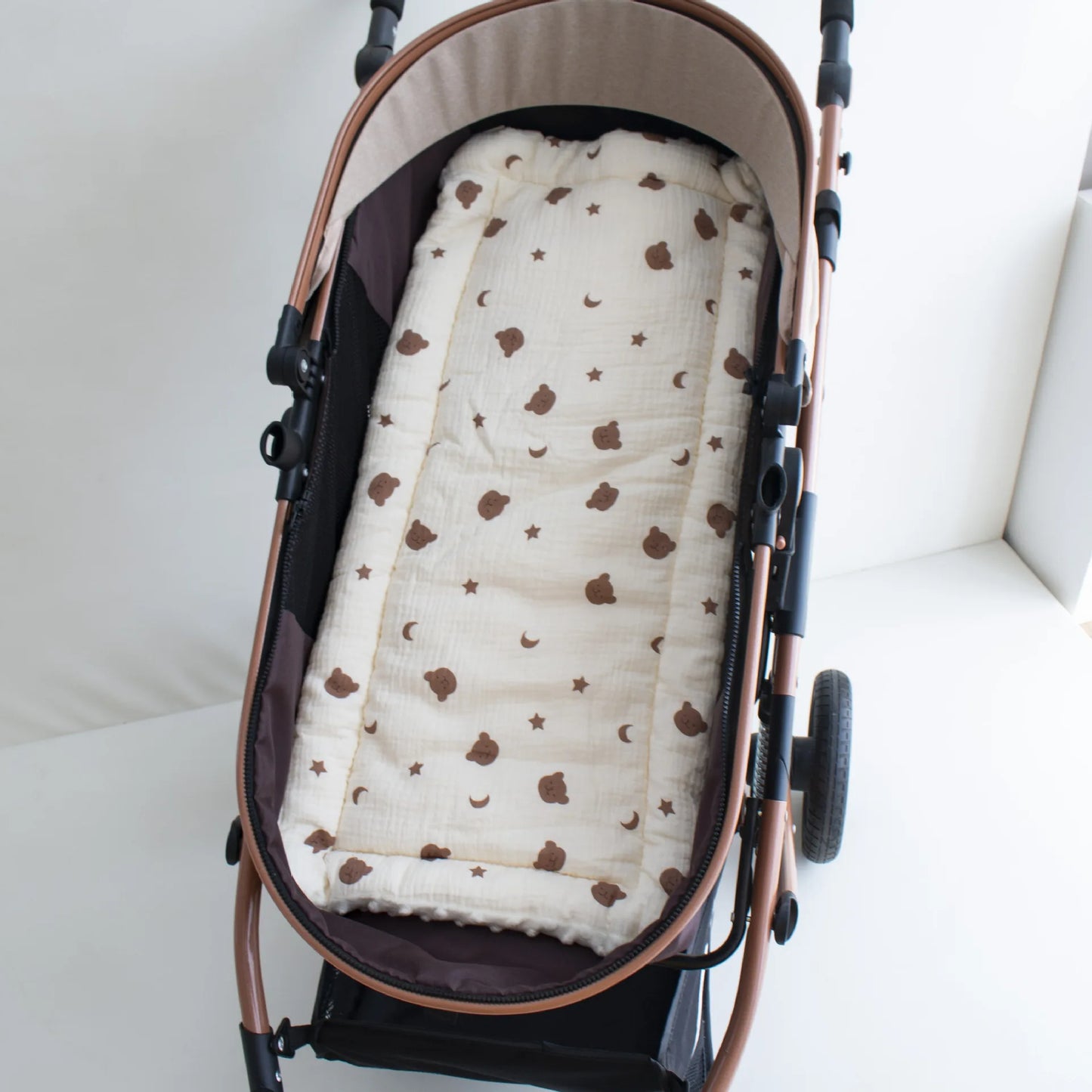 Soft beige stroller cushion with brown bear and star pattern, offering comfort for babies 1-2 years.