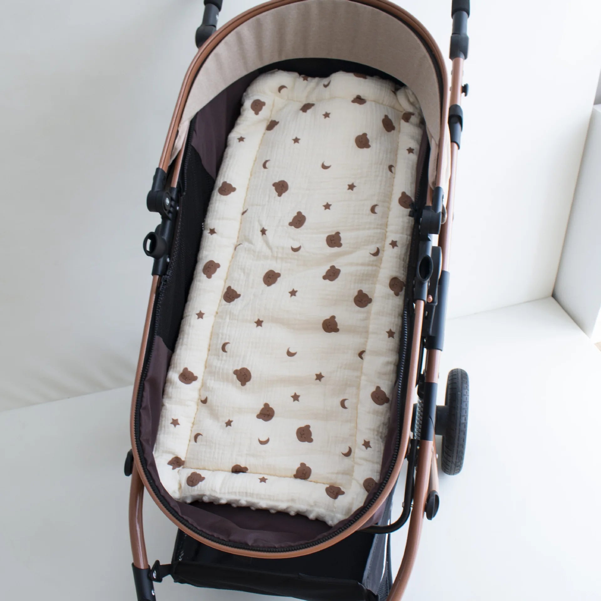 Soft beige stroller cushion with brown bear and star pattern, offering comfort for babies 1-2 years.
