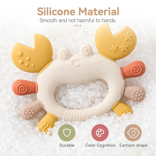 Beige and yellow silicone crab baby teether with textured claws and legs, on a bed of white beads.