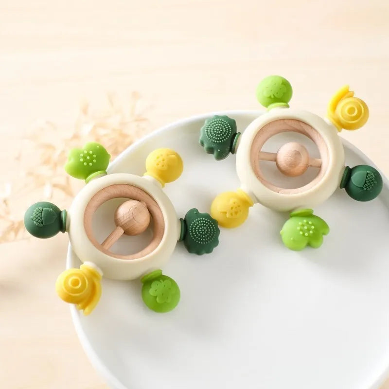 Montessori forest-themed silicone and wood baby teether with green and yellow animal shapes.