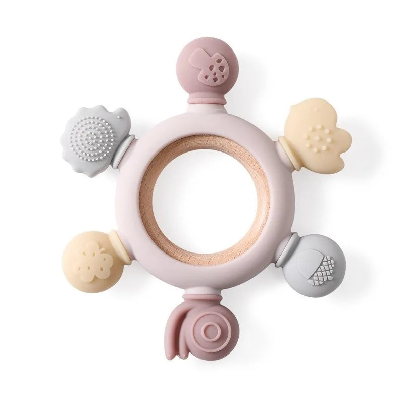 Montessori forest-themed baby teether with a wooden ring and soft silicone attachments in pastel colors.
