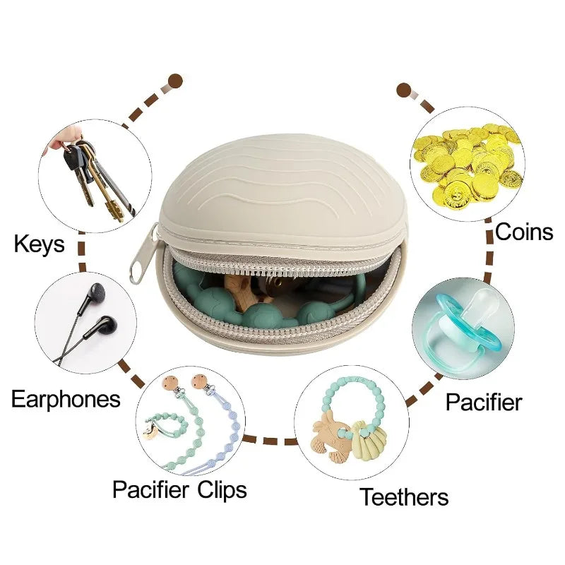 Beige seashell-shaped silicone pacifier case with zipper, shown holding a pacifier, teether, and other small items.
