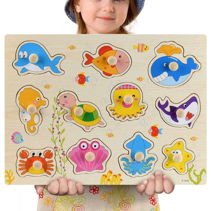 Child holding a wooden Montessori puzzle with colorful sea animal shapes and knobs.