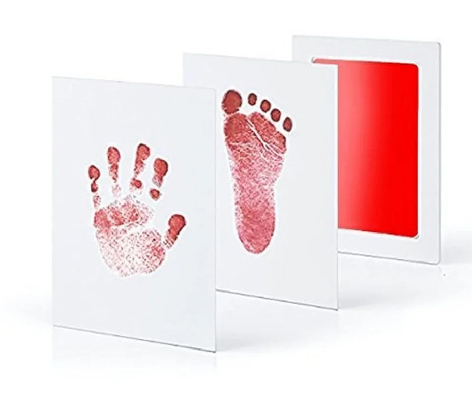 Baby handprint and footprint kit with red ink pad, white paper, and clear prints.